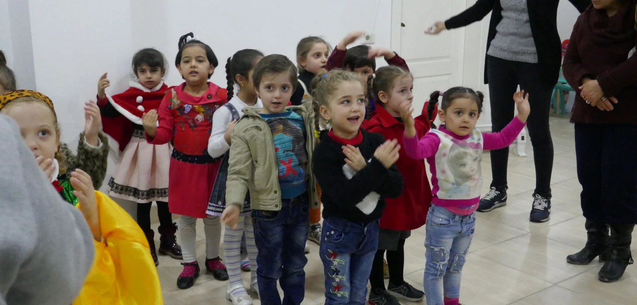 Des enseignants chrétiens du jardin d’enfants exécutent une danse dans la ville kurde d’Erbil. csi