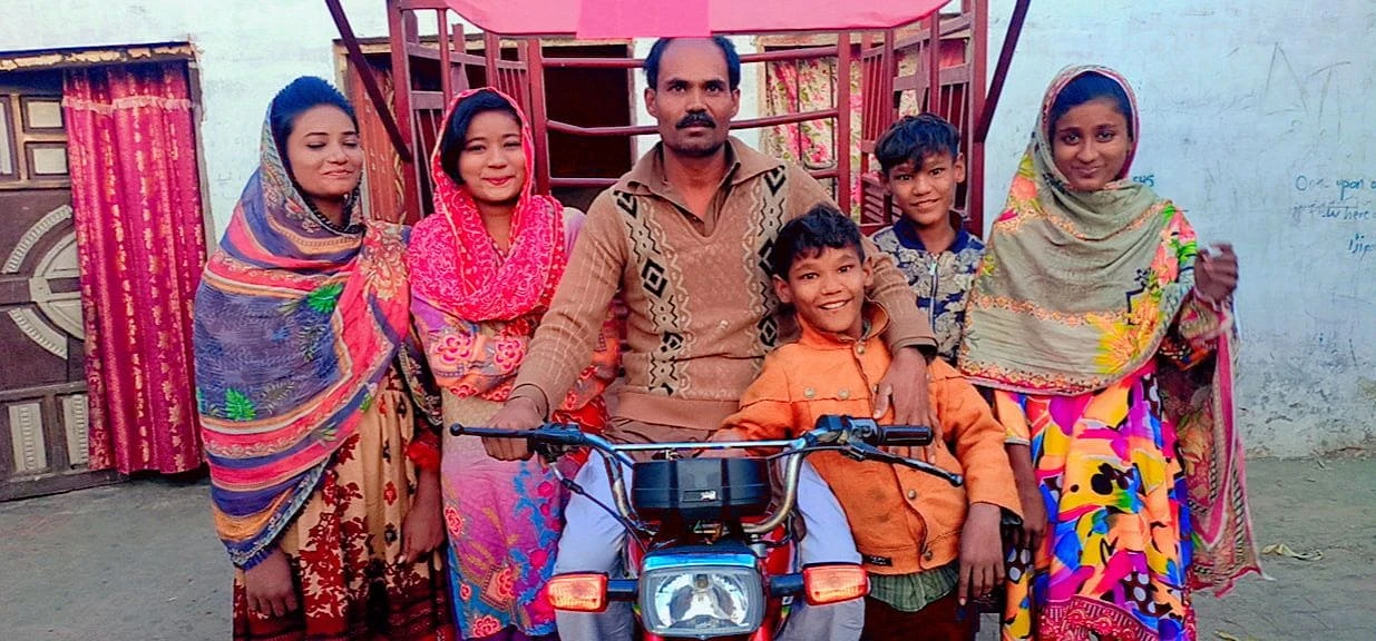 Le visage heureux et reconnaissant, Parvez et ses enfants présentent leur rickshaw. csi